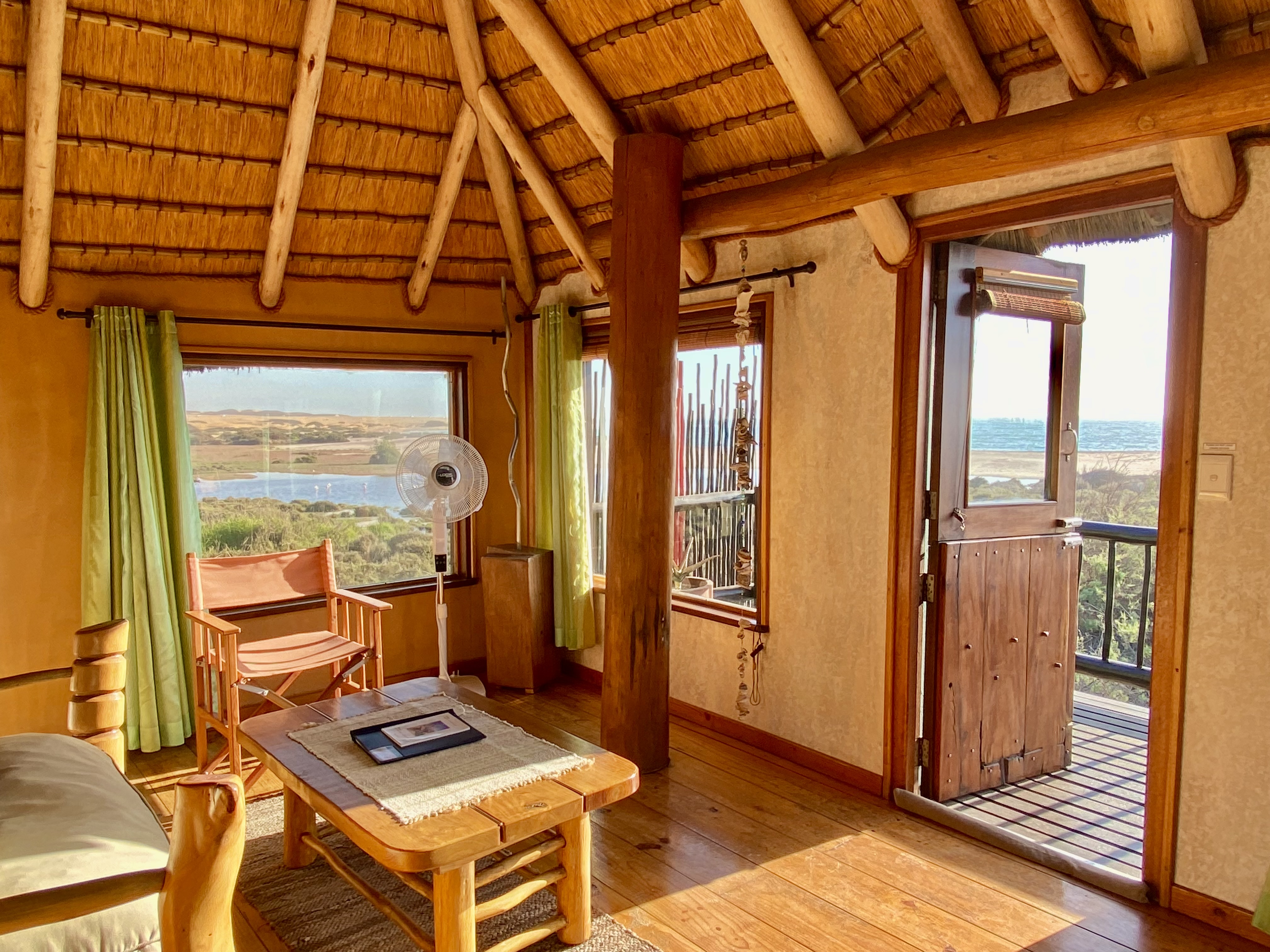 Lagoon Bungalow lounge with lagoon and ocean views through the windows and balcony door