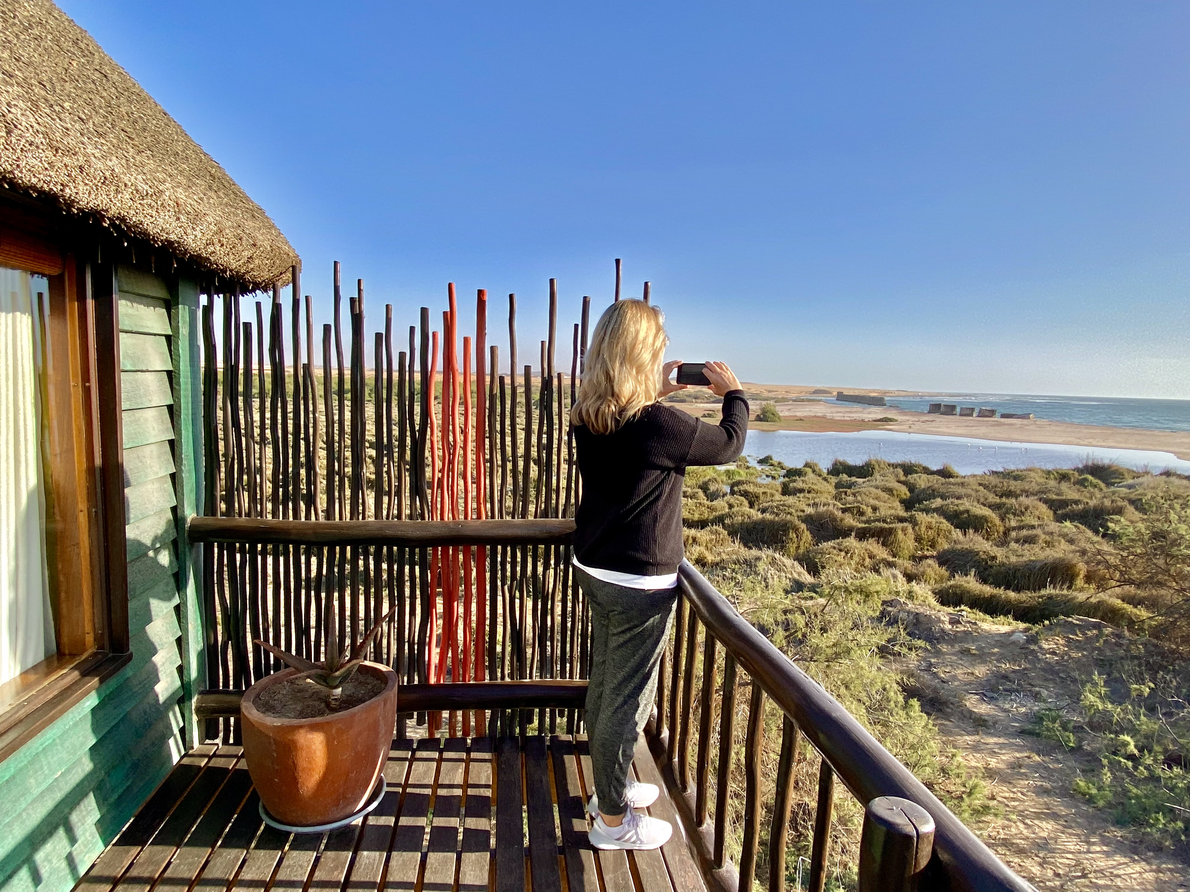 Guest photographing the lagoon and ocean from a Lagoon Bungalow balcony