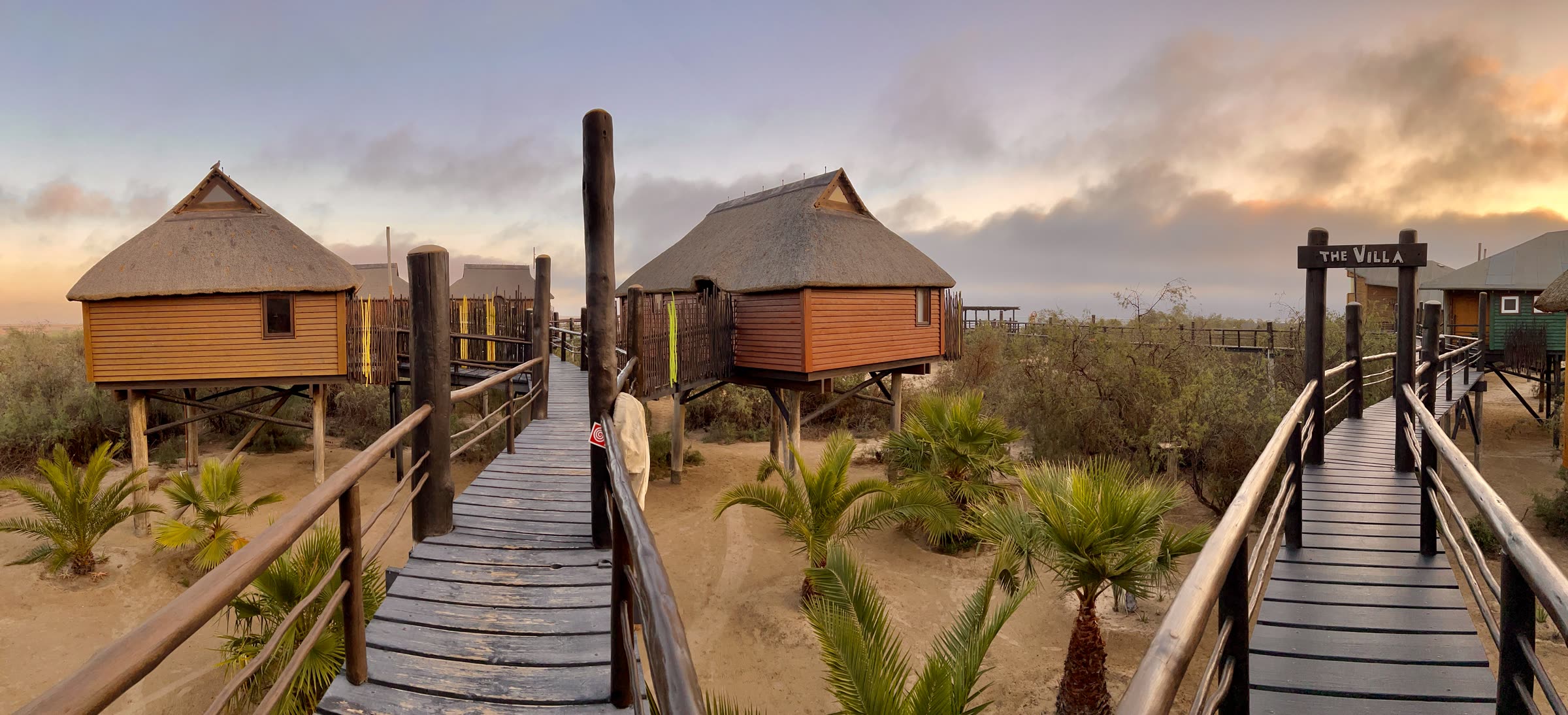 Panoramic sunset over bungalows and walkways at The Stiltz